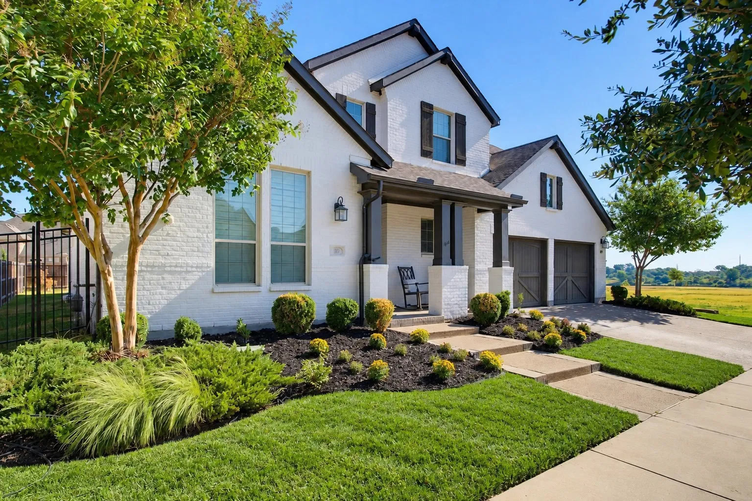 White brick exterior with dark trim accents and two-car garage