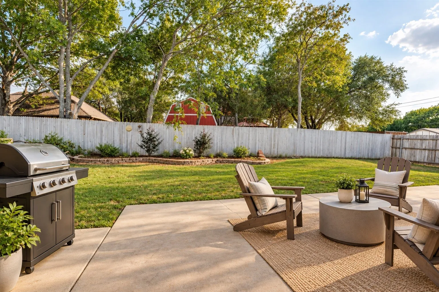 Expansive backyard featuring a concrete patio, a manicured lawn, mature trees, and a privacy fence
