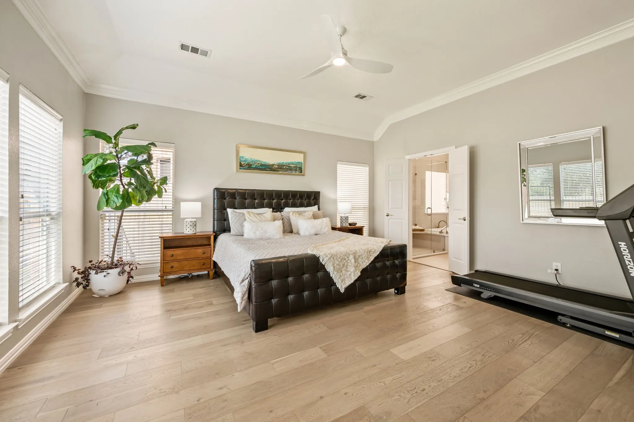 Large primary bedroom with room for a treadmill and sitting area.
