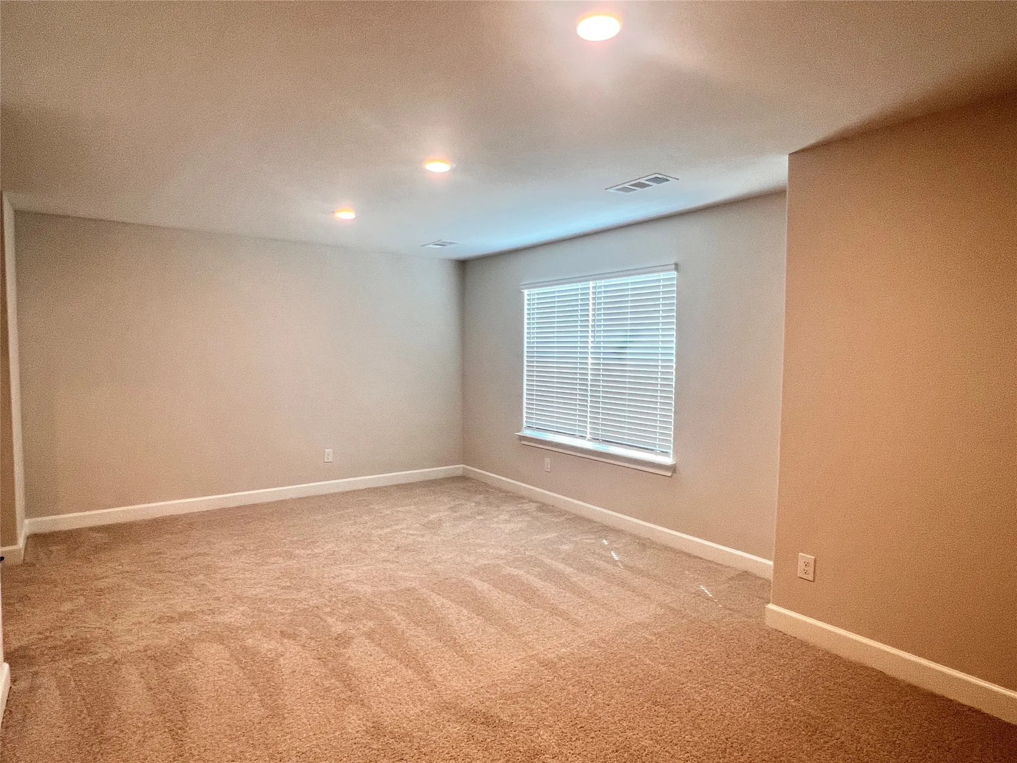 Recessed lighting, neutral wall tones, carpeted flooring, window with blinds, and white trim