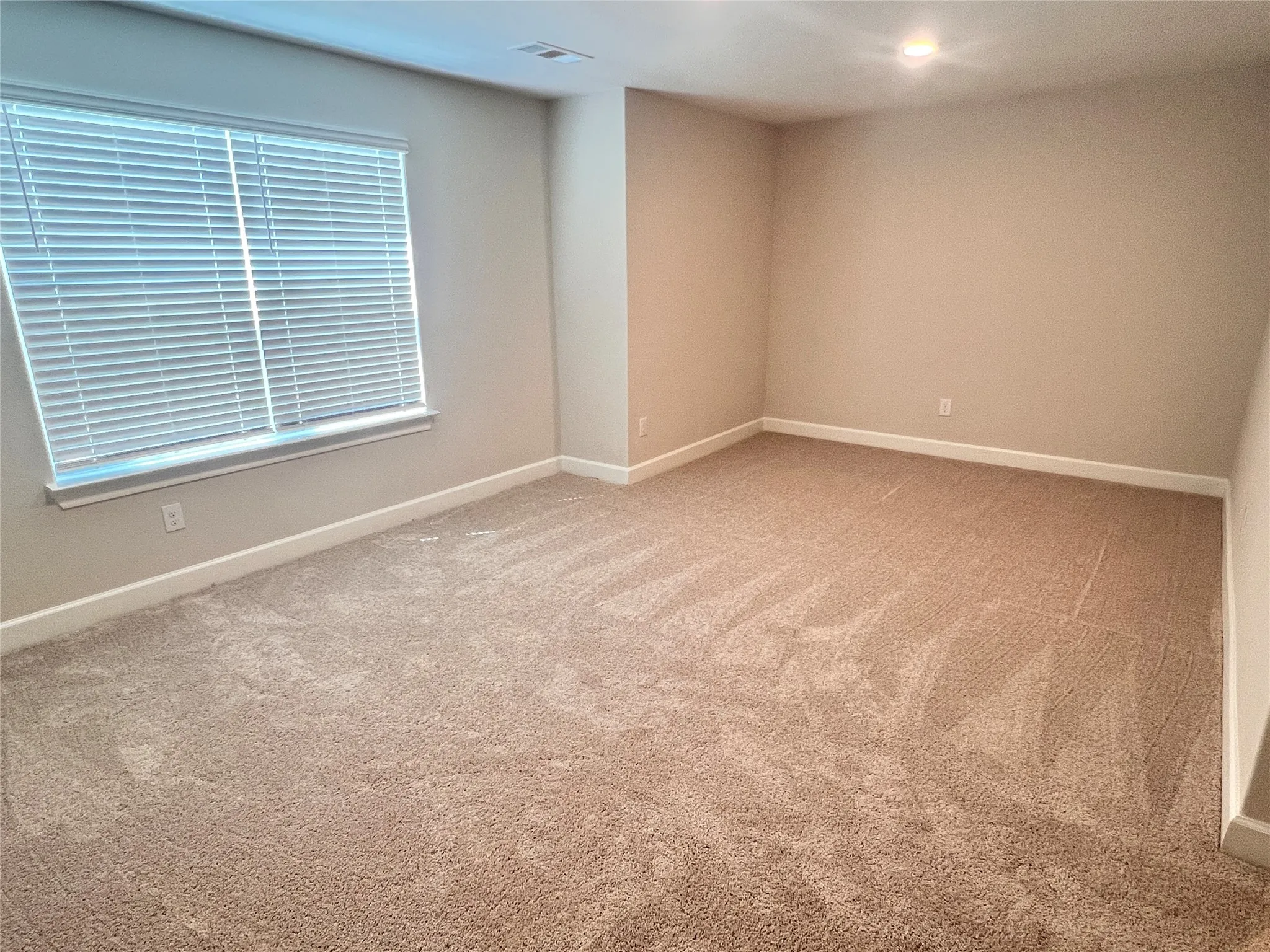 Recessed ceiling lighting, neutral-toned walls, plush carpet flooring, window with blinds, and white trim