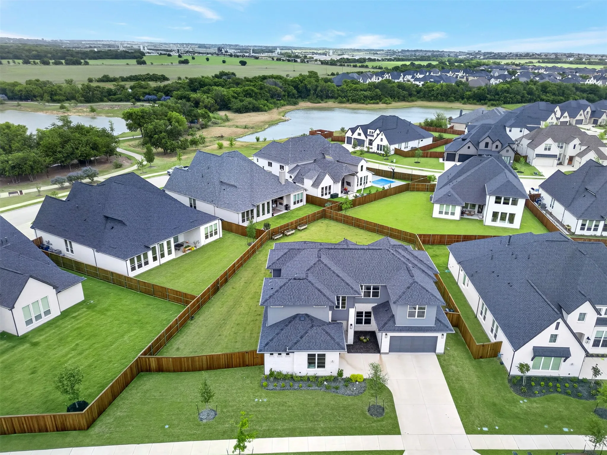 Two-story residence with a multi-gabled roof, attached two-car garage, and a fenced backyard