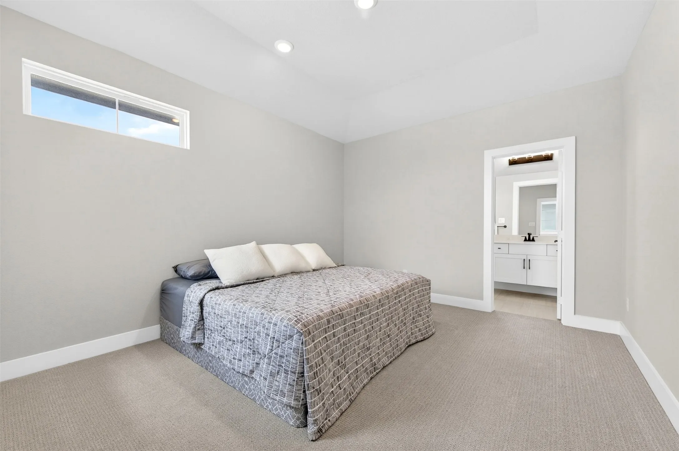 Recessed lighting, vaulted ceiling, high transom window, neutral carpet, and white trim