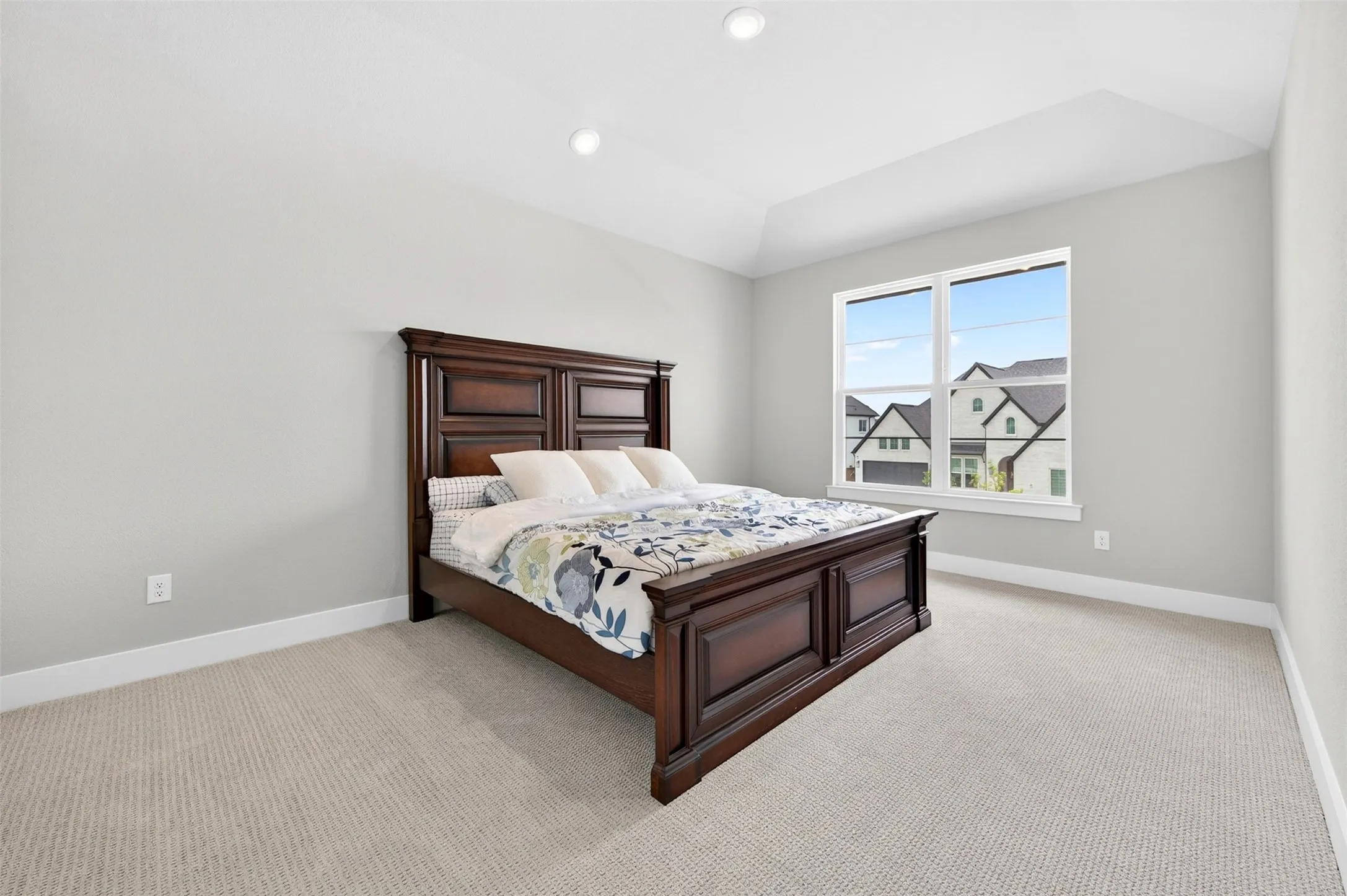 Recessed lighting, tray ceiling, large window with white trim, light neutral wall color, and plush carpet flooring