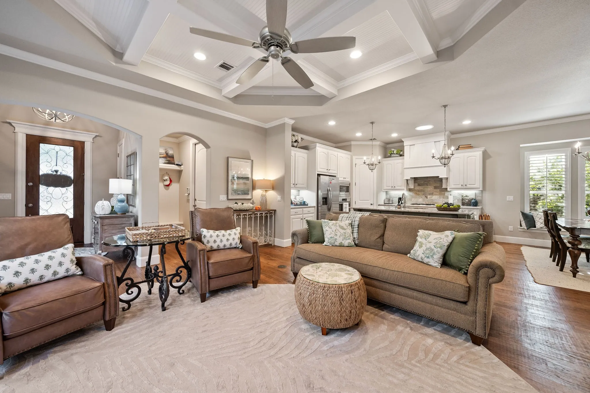 Open-concept living area featuring a tray ceiling with wood-finish accents, recessed lighting, and a ceiling fan