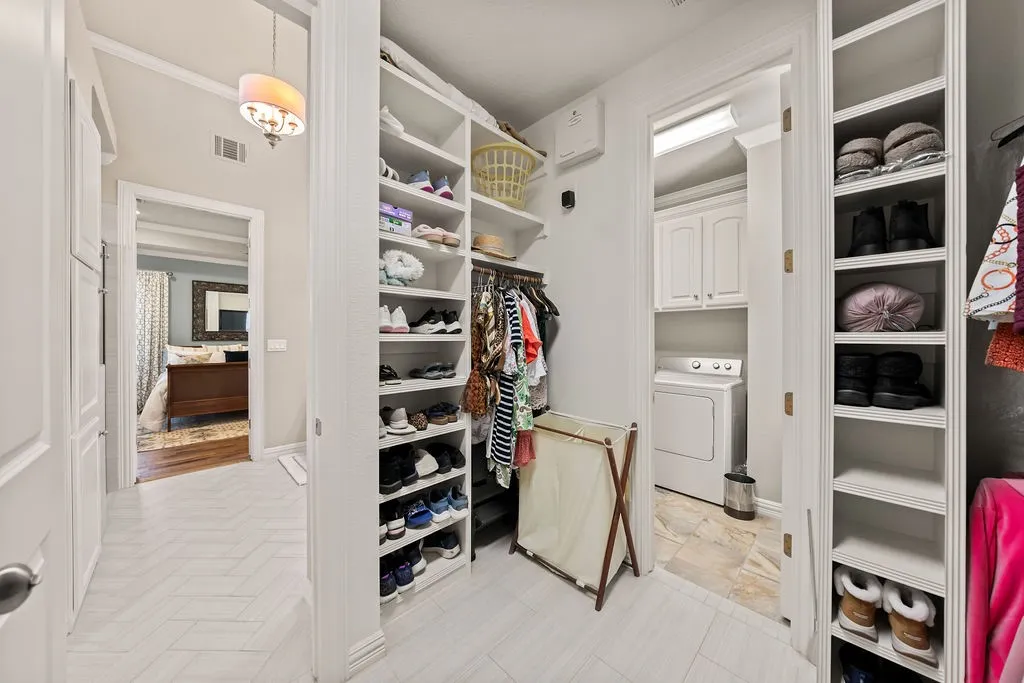 Built-in shelving, clothes hanging rod, chevron-patterned flooring, recessed lighting, and a built-in cabinet