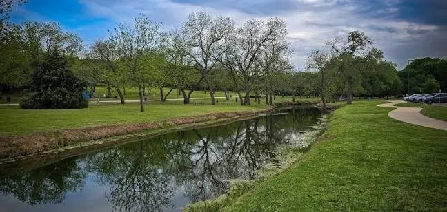 Canal with surrounding grassy banks and mature trees