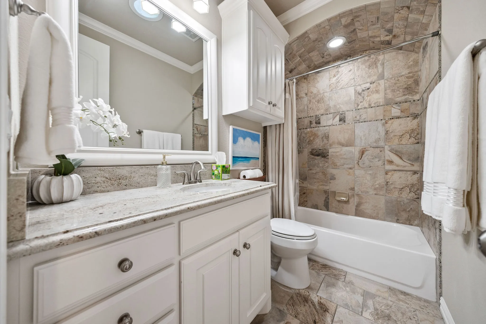 White vanity with a light-toned countertop and an undermount sink