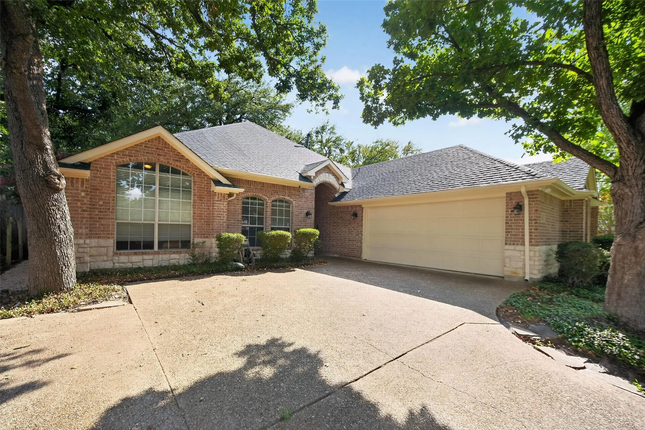 Brick exterior with stone accents, a gabled roofline, and an attached two-car garage