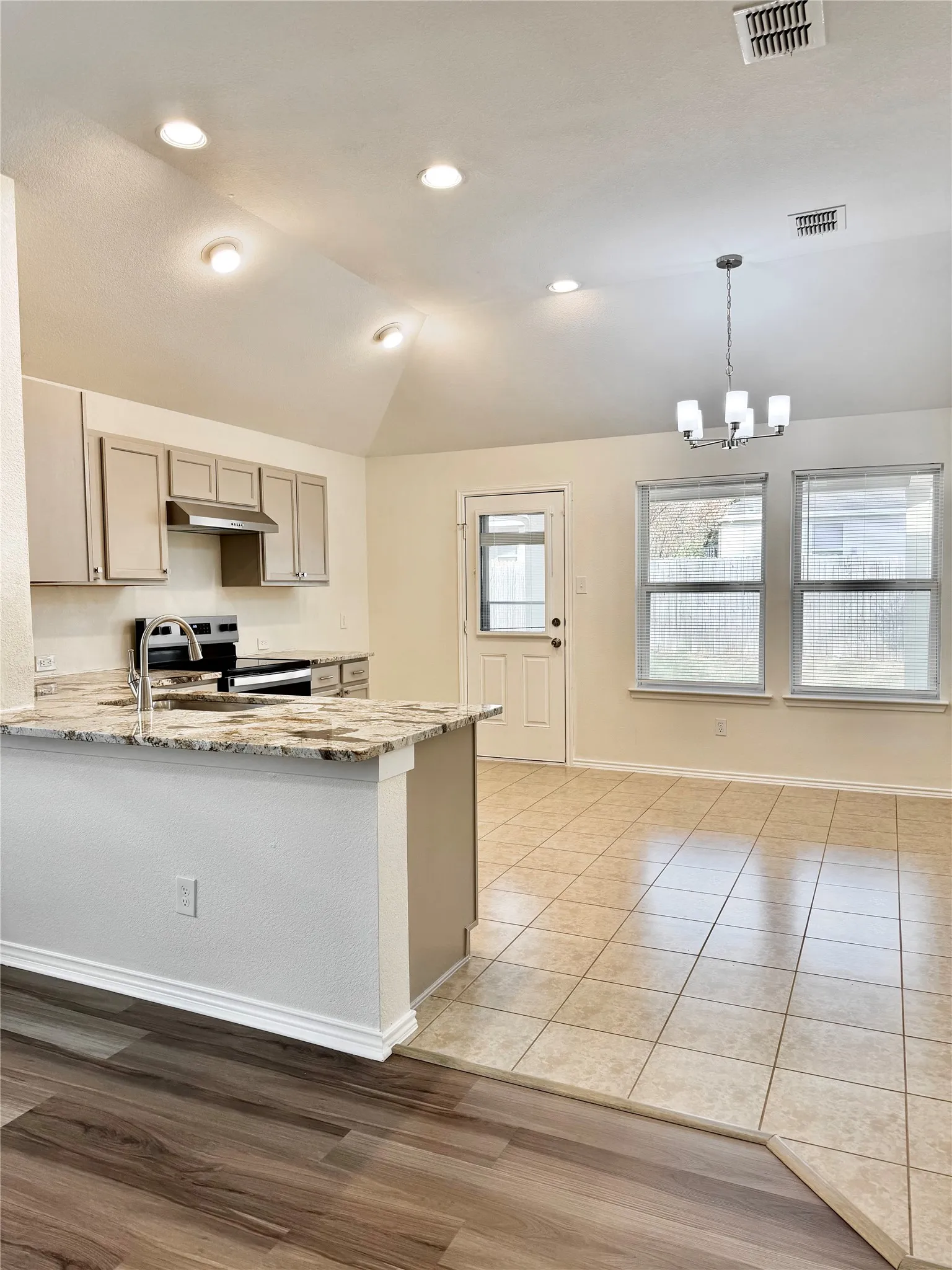 Kitchen featuring light-toned cabinetry, stainless steel appliances, and a central island with a light-toned countertop