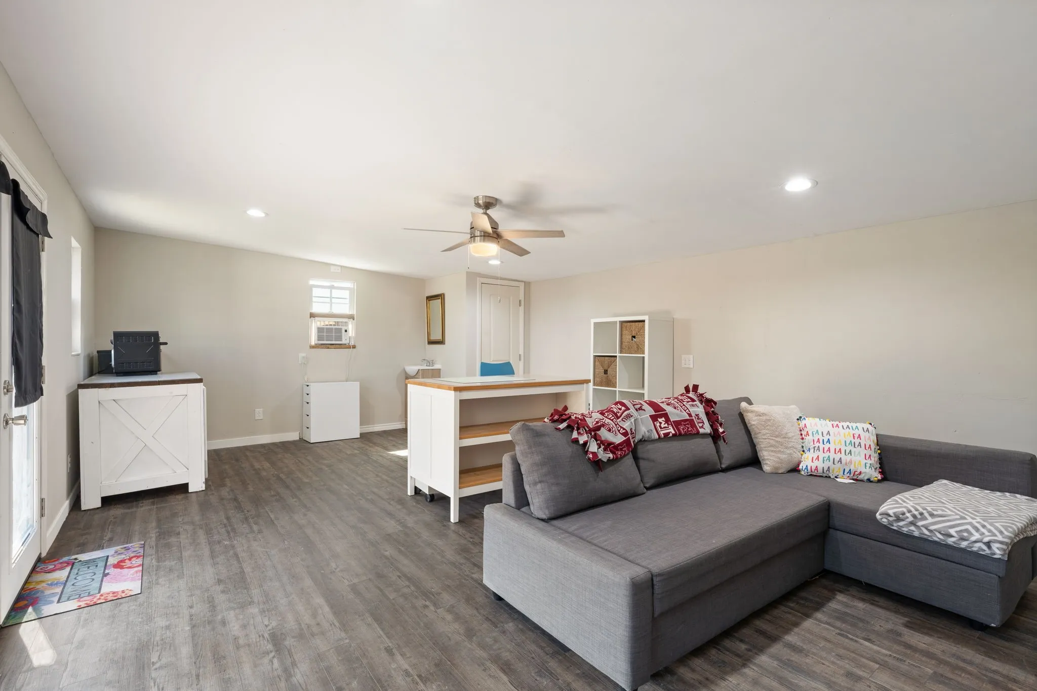Recessed lighting, ceiling fan, wood-finish flooring, built-in shelving, and light-toned walls