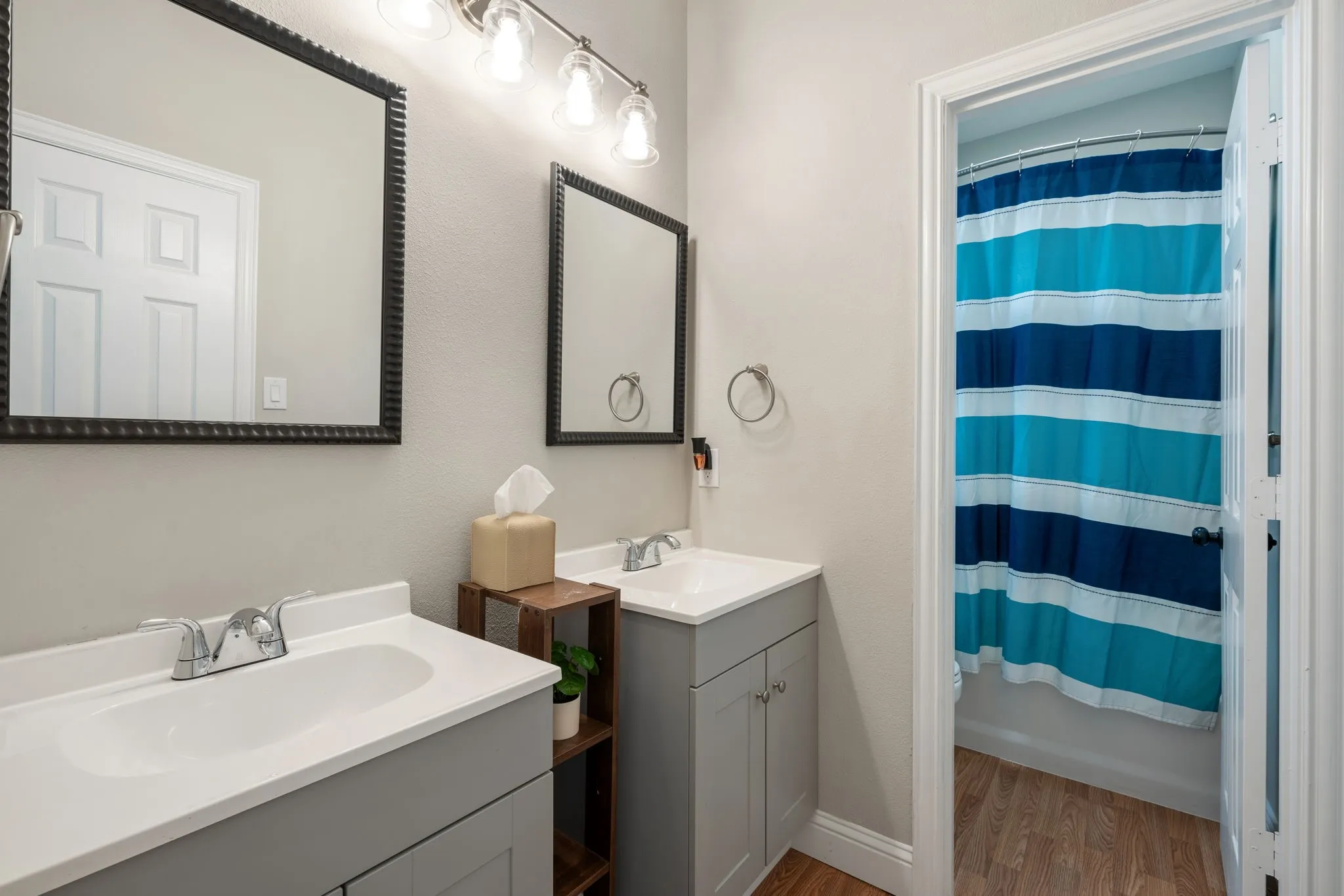 Dual vanity with gray cabinetry, integrated sinks, and chrome faucets