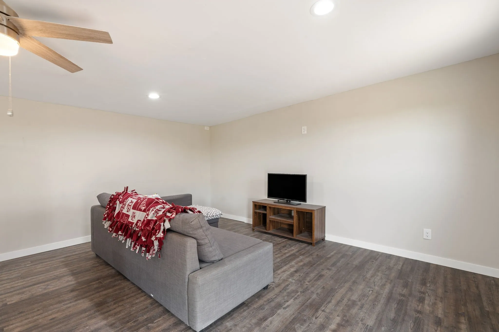 Wood-finish flooring, recessed lighting, ceiling fan with integrated light, and neutral wall tones