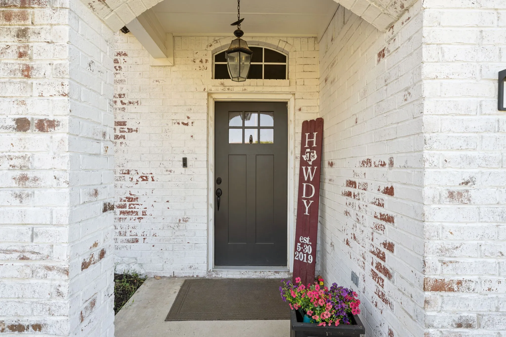 White-washed brick exterior featuring an arched entryway