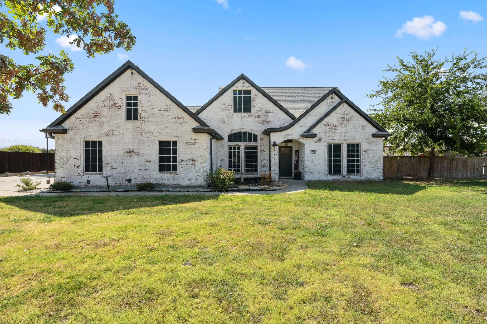 White brick exterior with dark trim and multiple gables
