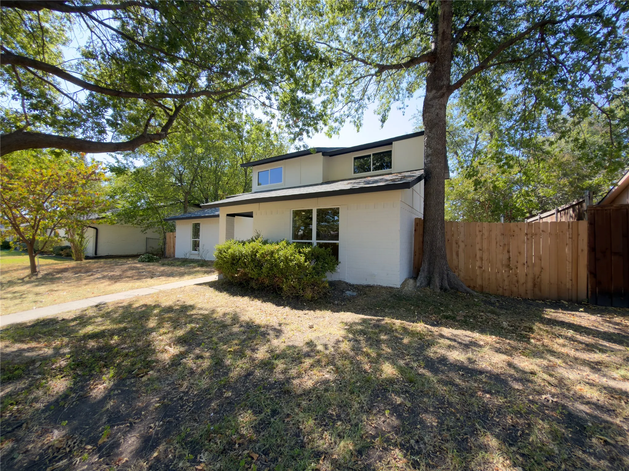Contemporary exterior with white brick, dark trim, and multiple windows