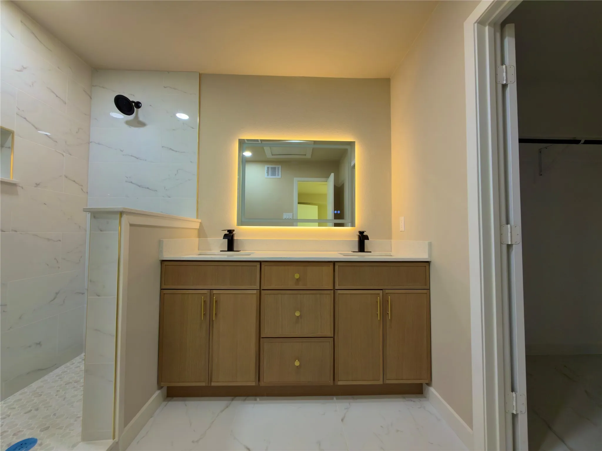 Dual sink vanity with light wood-finish cabinetry and quartz countertop