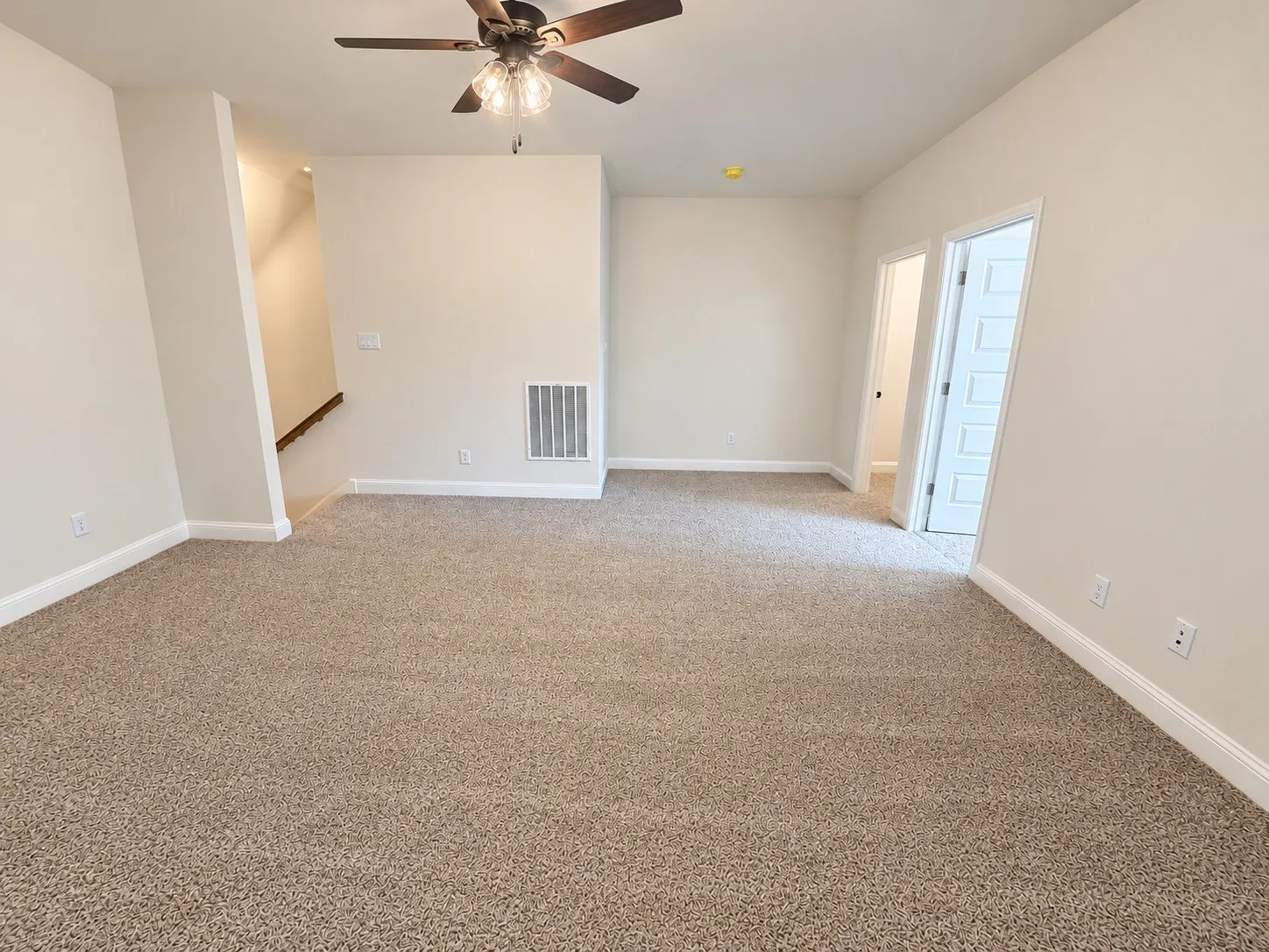 Neutral-toned carpeting, ceiling fan with integrated lighting, white trim and baseboards, and a paneled door