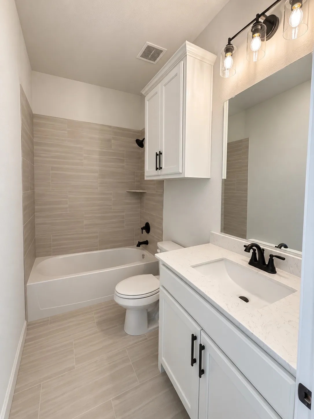 White vanity with a light-toned countertop, integrated sink, and matte black faucet