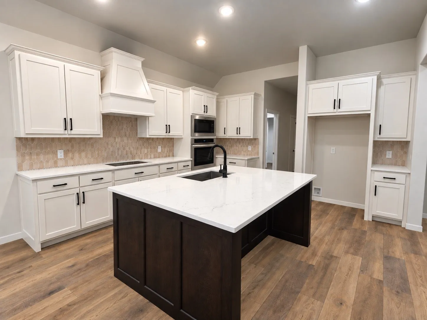 Kitchen featuring white cabinetry, dark wood-finish island, light-toned backsplash, stainless steel appliances, and wood-finish flooring