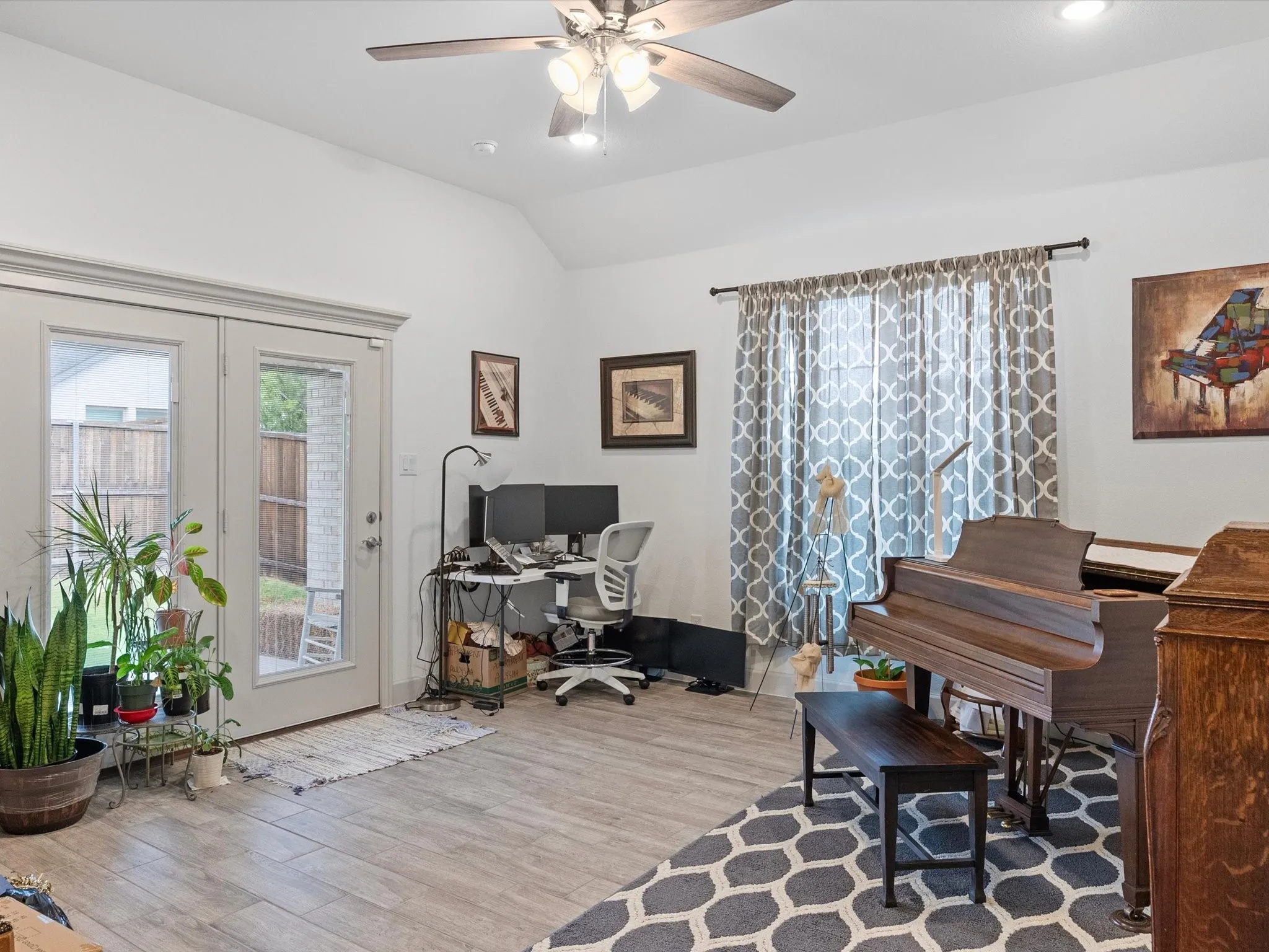 Vaulted ceiling with a ceiling fan, light wood-finish flooring, recessed lighting, and double-paned glass doors