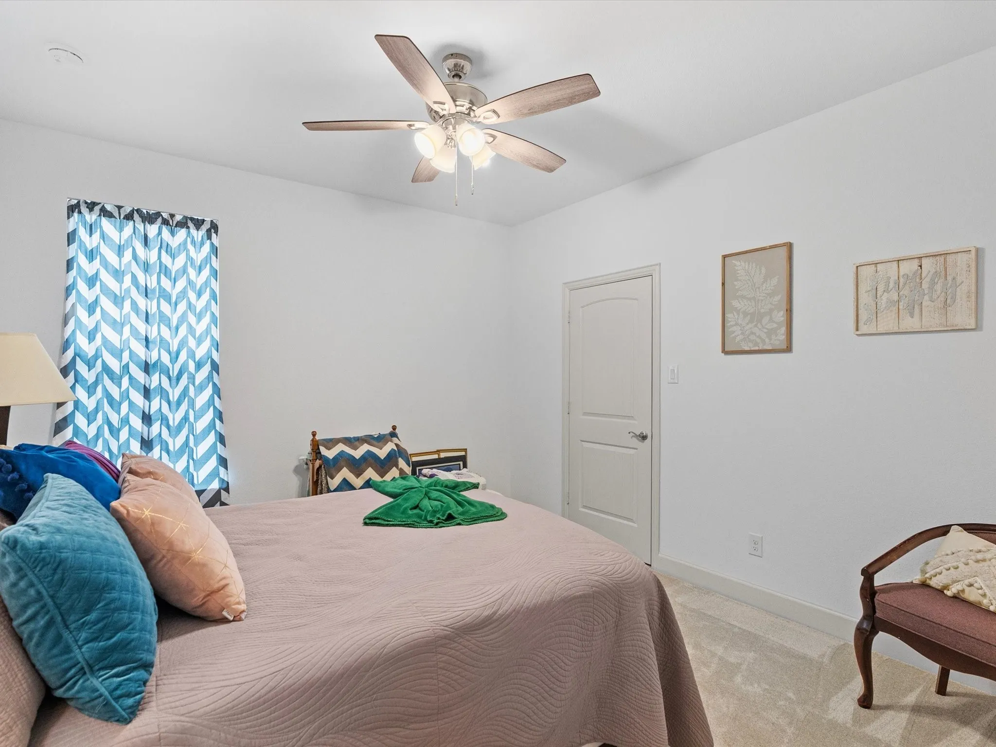 Carpeted flooring, white walls, and a ceiling fan with integrated lighting