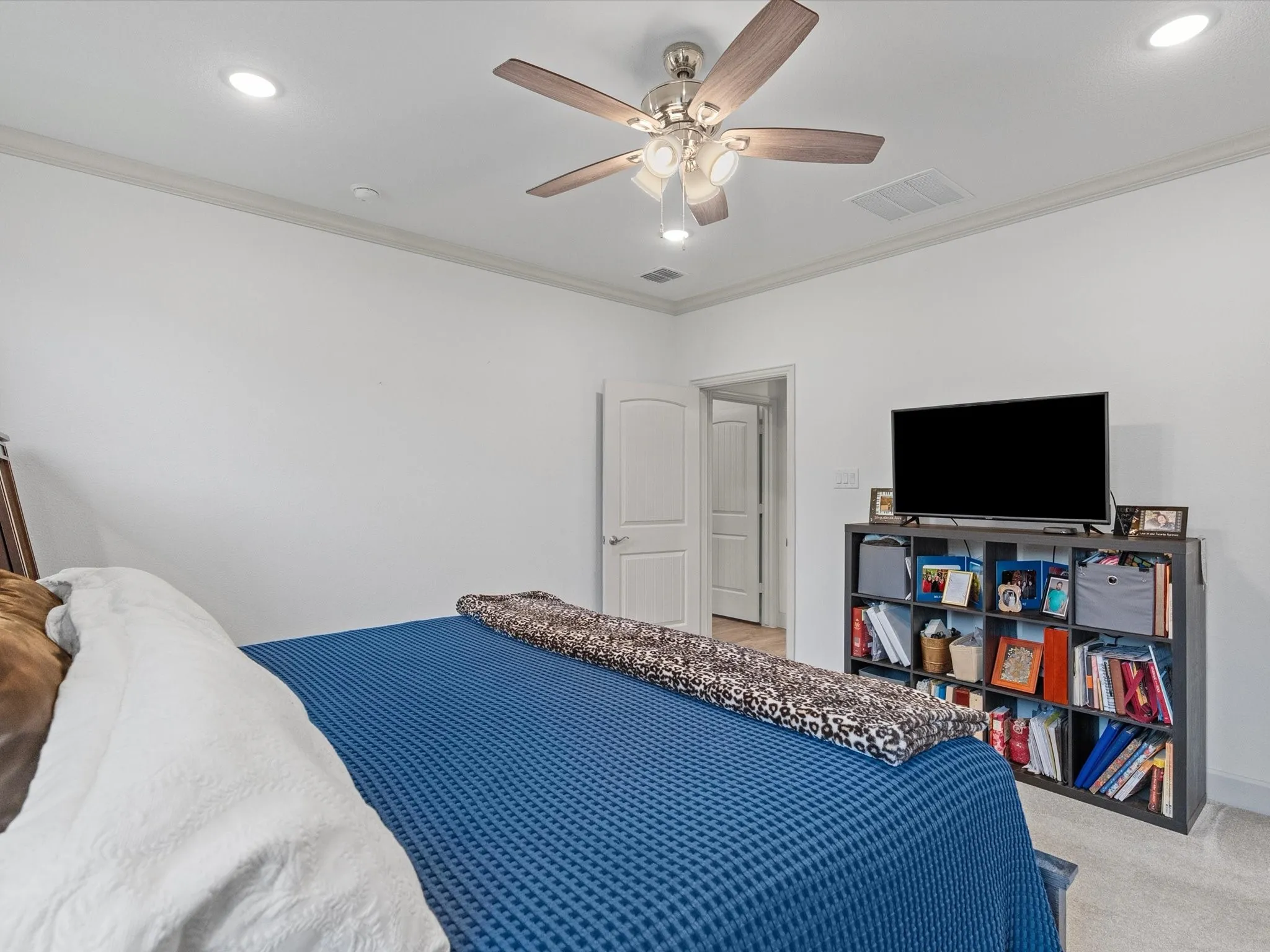 Recessed ceiling lighting, crown molding, and a ceiling fan with light fixture