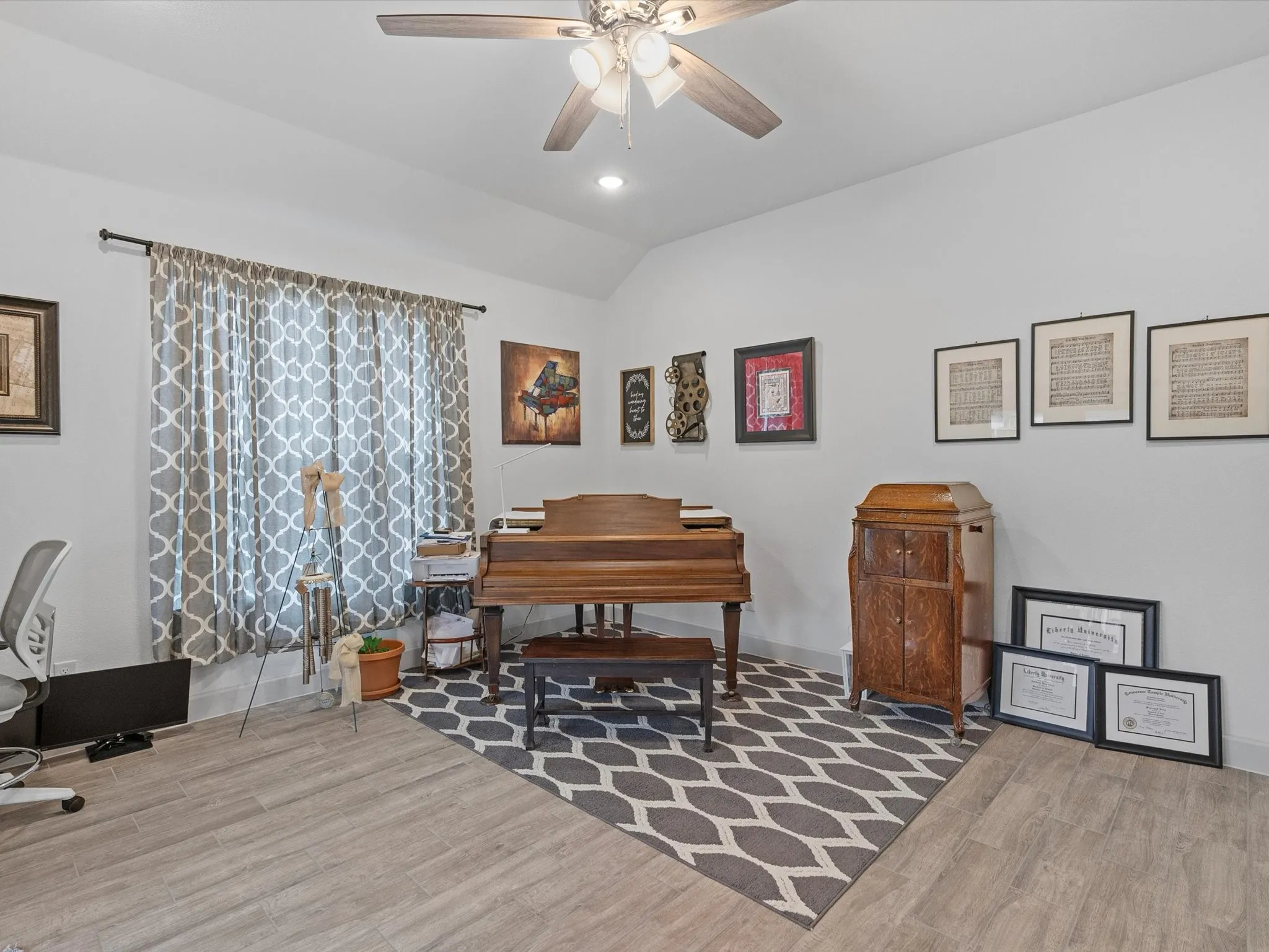 Wood-finish flooring throughout, recessed ceiling lighting, and a ceiling fan with integrated light