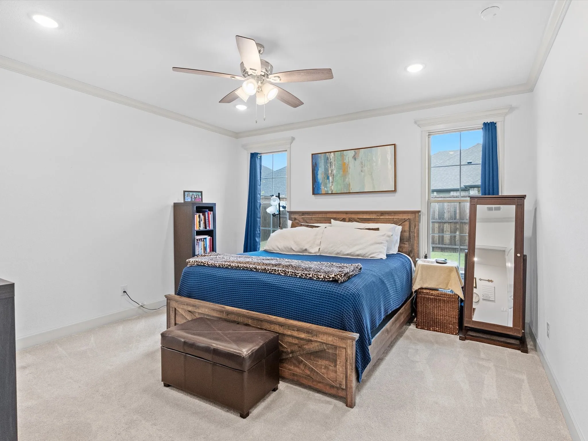 Recessed lighting, ceiling fan, crown molding, two windows, and light-toned carpeting