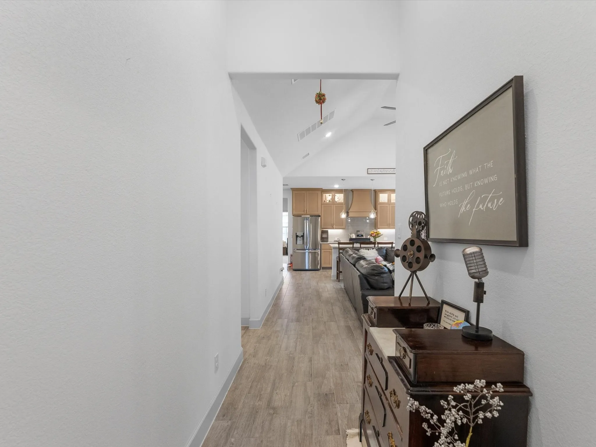 Hallway with wood-finish flooring, vaulted ceiling, and recessed lighting