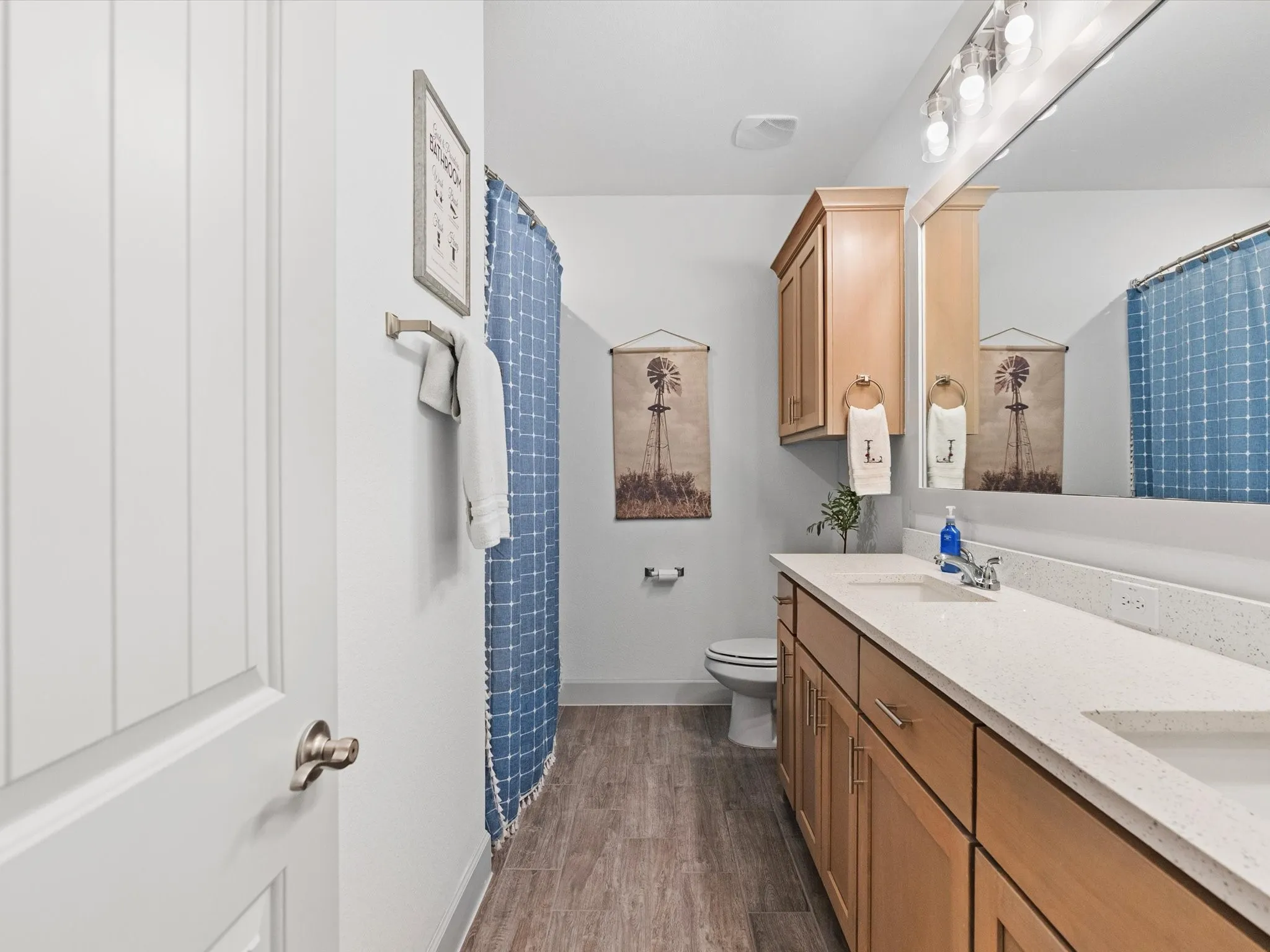 Bathroom featuring a double vanity with light-toned wood cabinetry and light-colored countertops