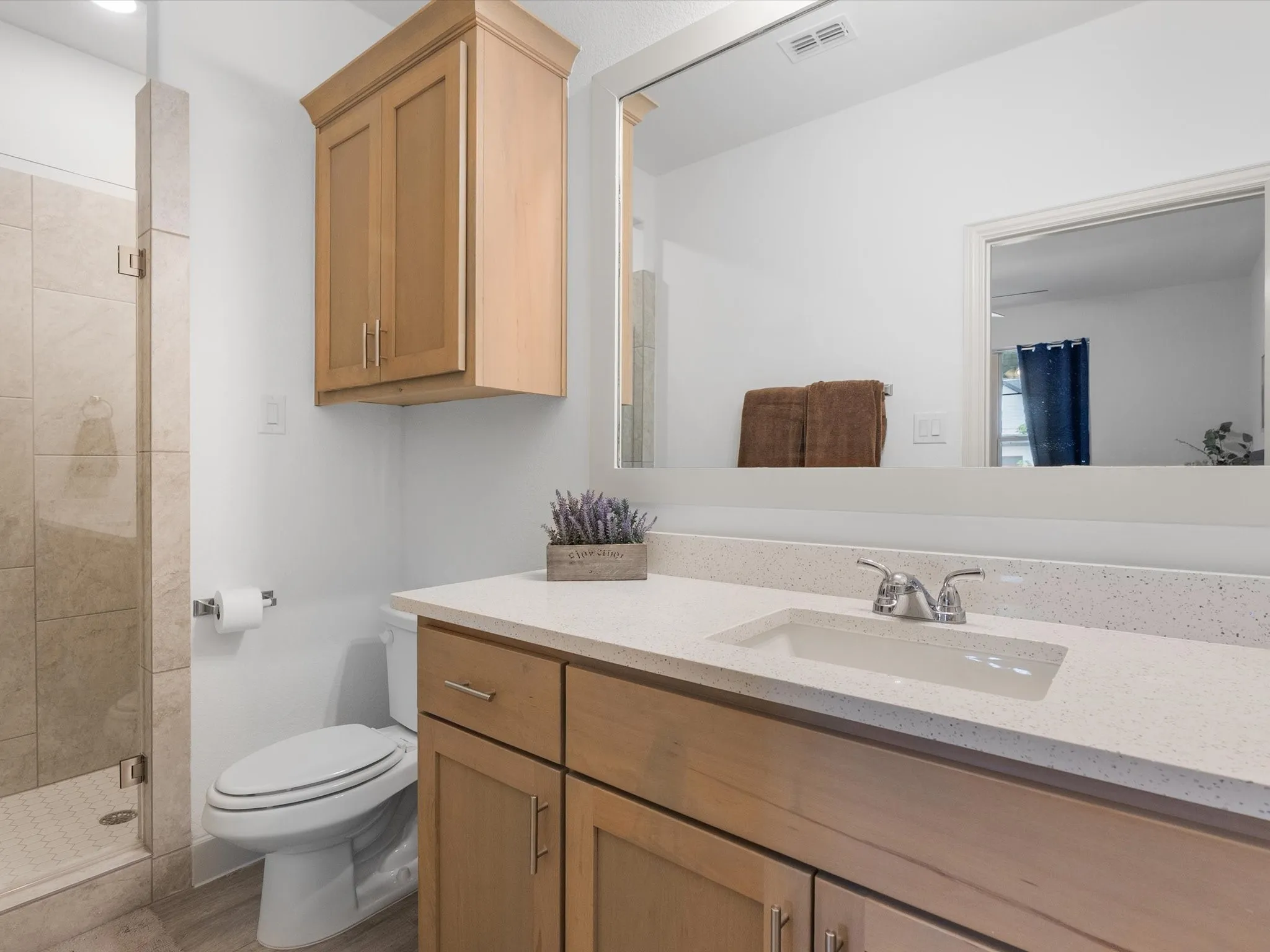 Light-toned wood-finish vanity with an integrated sink and light-toned solid surface countertop