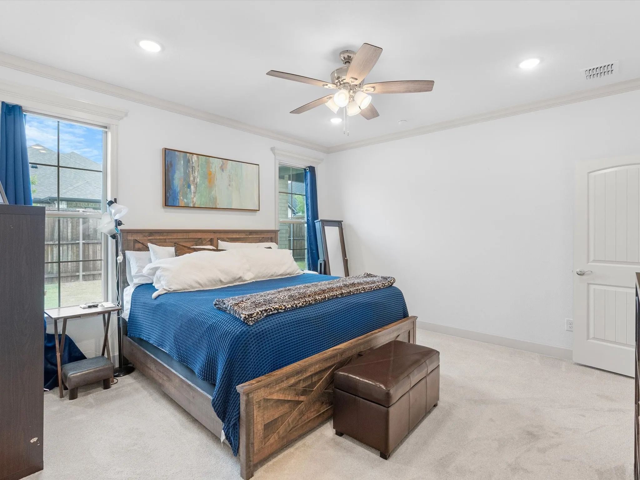 Recessed ceiling lighting, ceiling fan fixture, crown molding, white paneled door, and carpet flooring