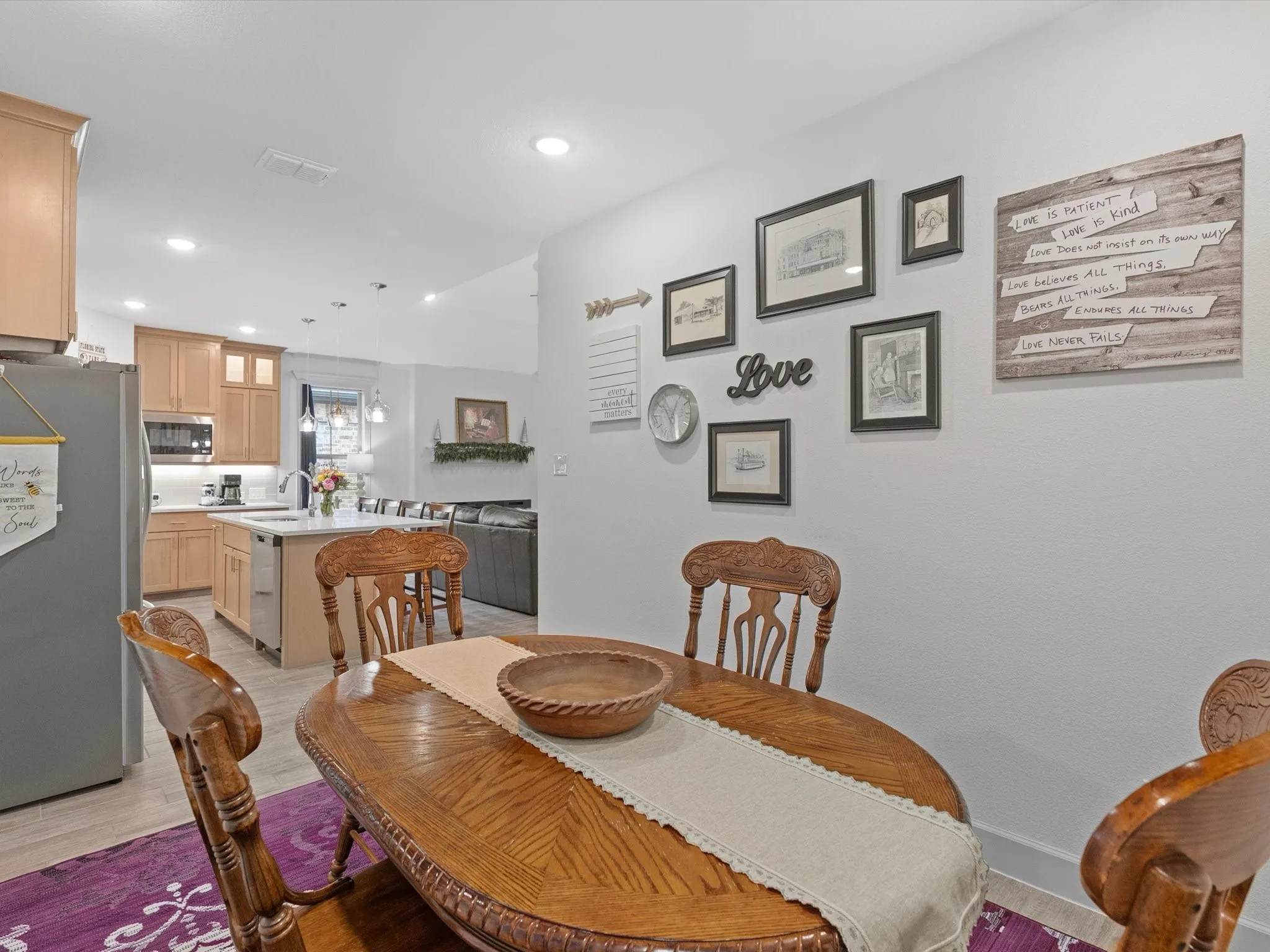 Wood-finish flooring, recessed lighting, kitchen with light wood cabinetry, kitchen island with seating, pendant lighting