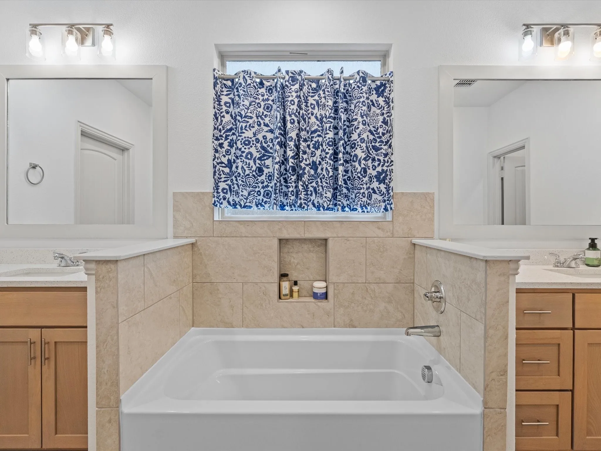 Built-in bathtub with tiled surround featuring an integrated niche