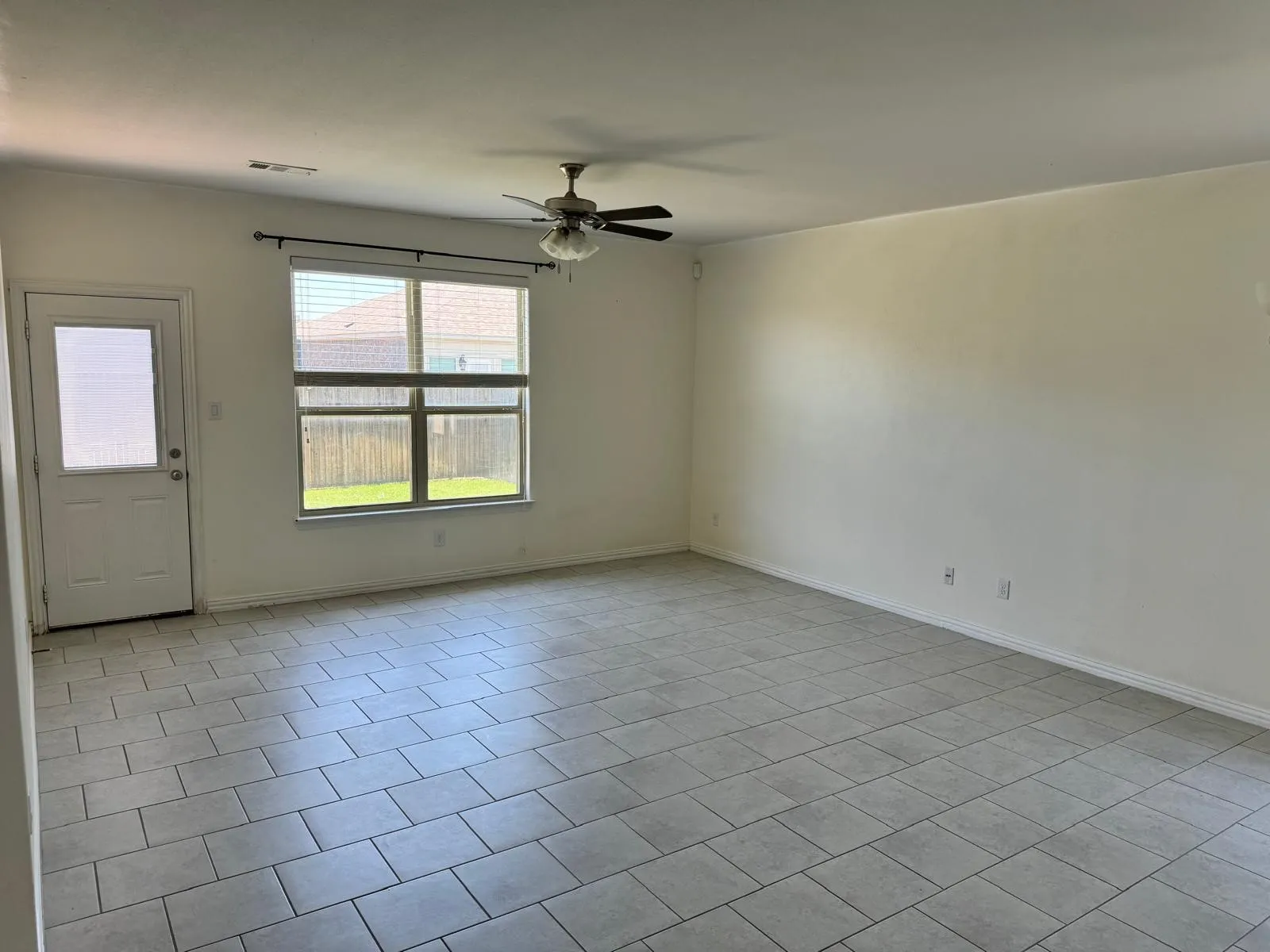 Tiled empty room with ceiling fan