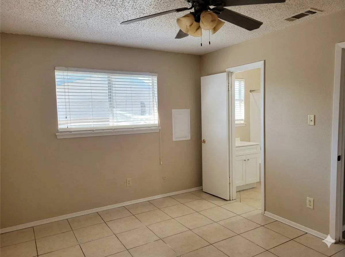 Tile flooring, window with blinds, ceiling fan with light fixture, neutral wall color