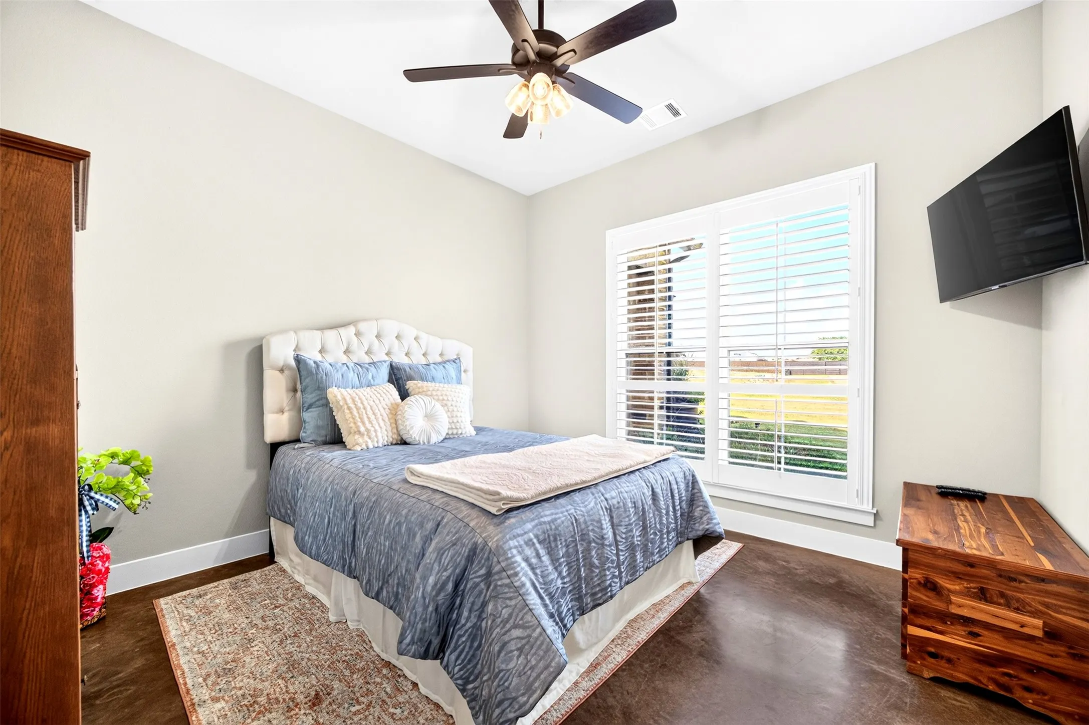 Becroom with plantation shuttrs and ceiling fan