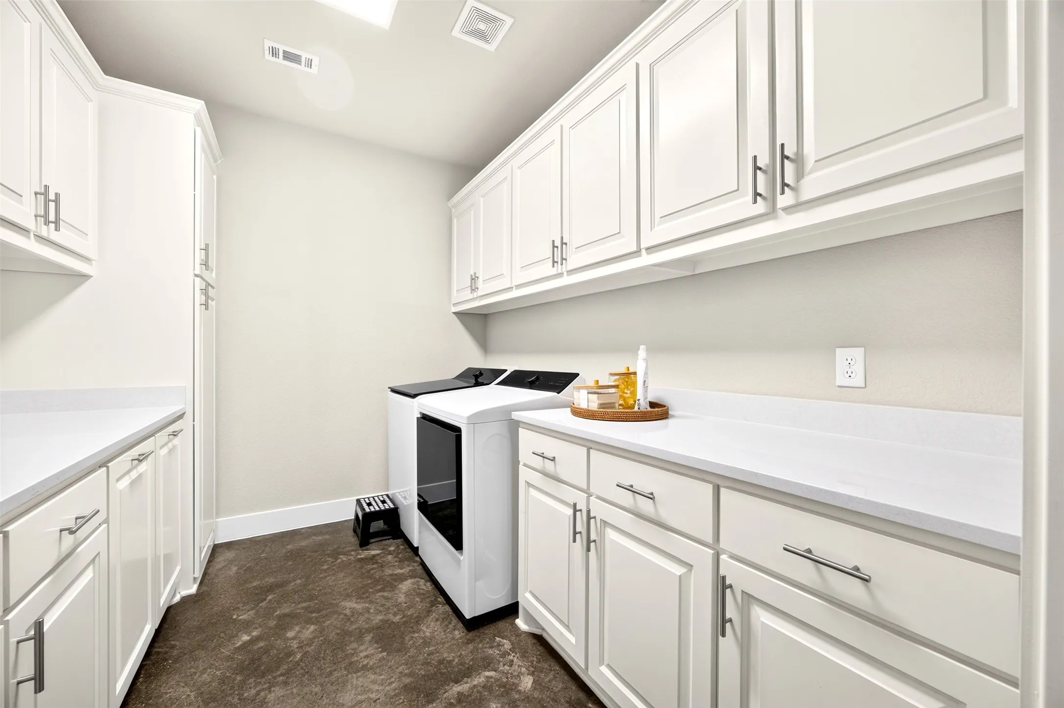 Oversized laundry room with ample cabinetry and counter space