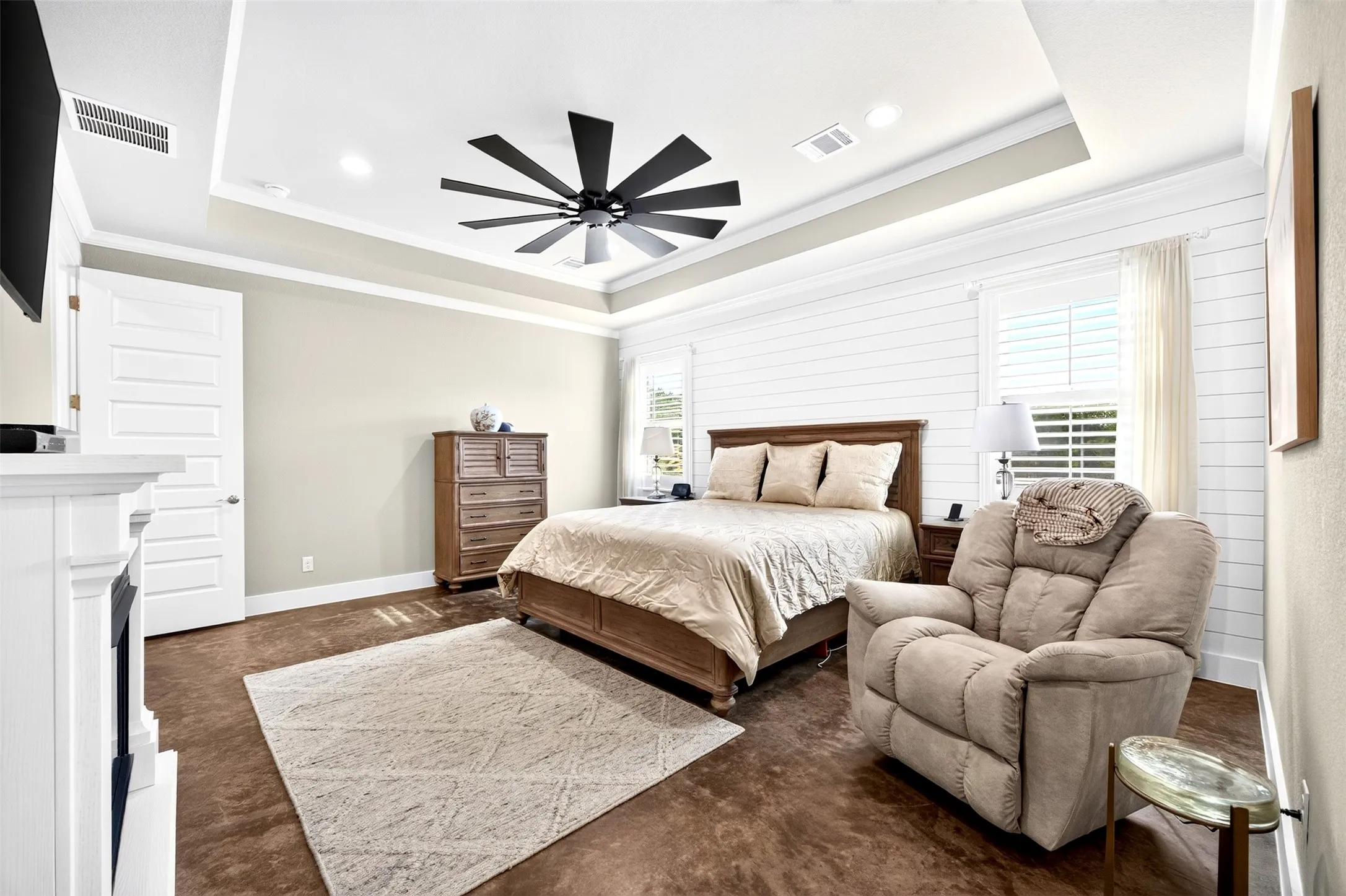 Primary suite with tray ceiling, ceiling fan, plantation shutters