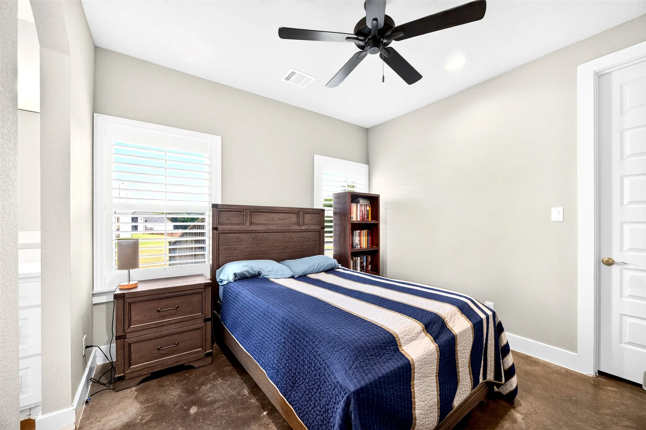 Bedroom with ceiling fan, plantation shutters and walk-in closet