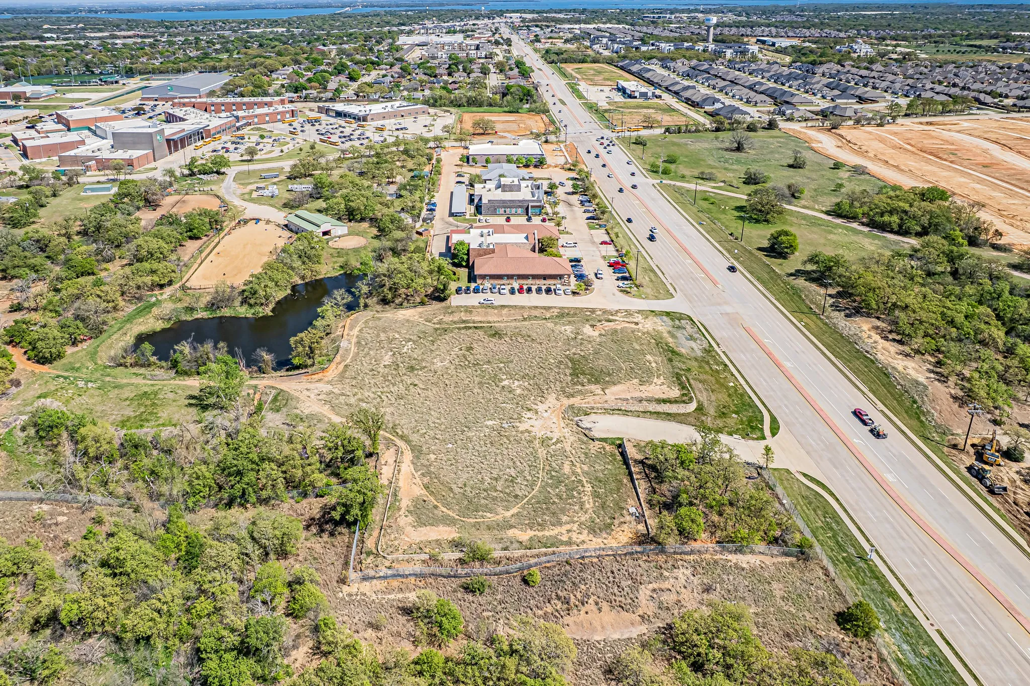Expansive undeveloped parcel featuring mature trees, a natural pond, and direct road frontage
