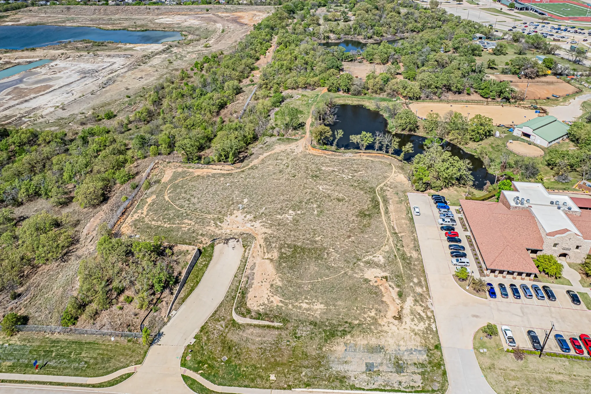Expansive undeveloped land featuring a paved access road and adjacent water body
