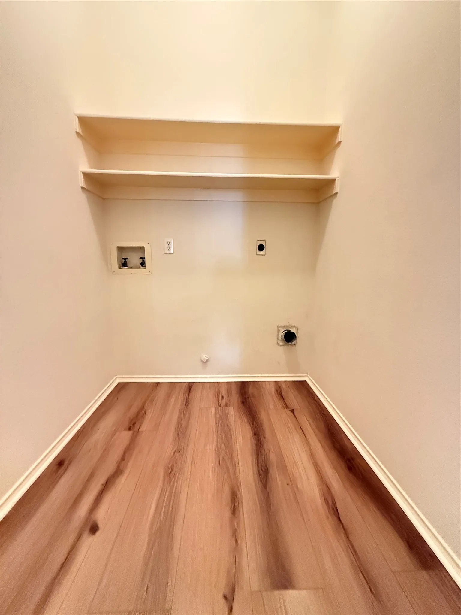 Wood-finish flooring with white trim and built-in shelving
