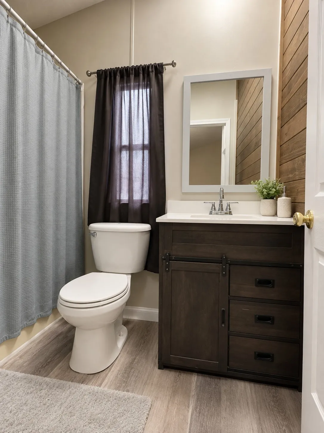 Guest. Wood-finish flooring, white vanity with integrated sink, rectangular mirror, and shiplap-style accent wall