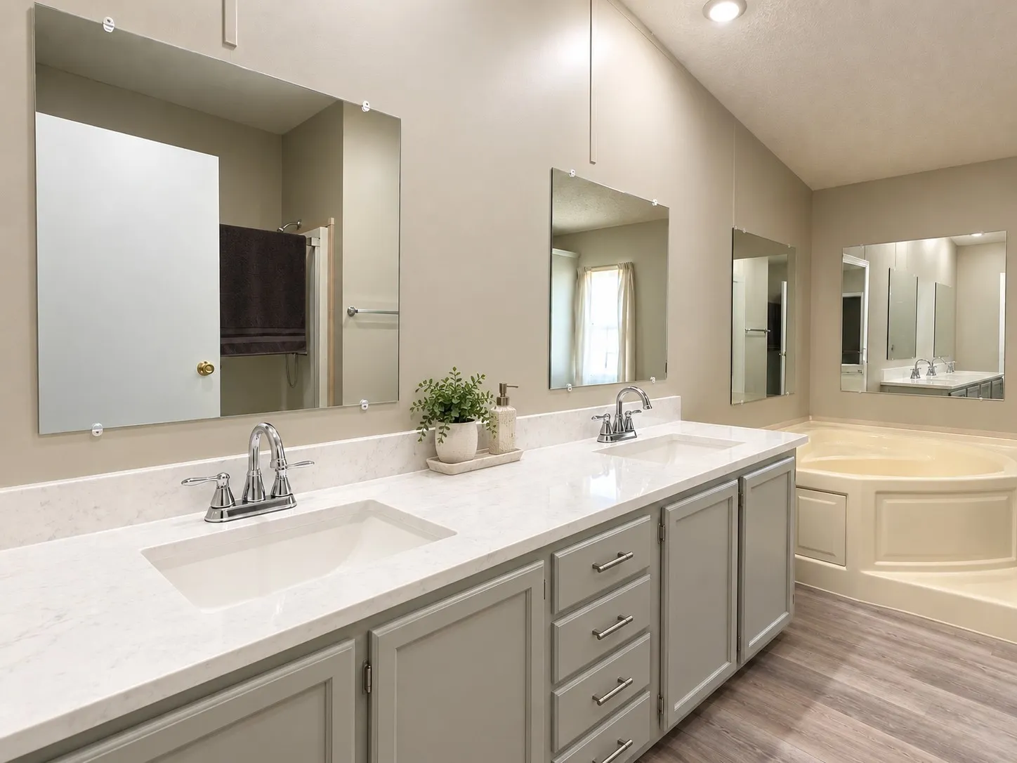 Primary. Dual vanity with white countertops, chrome fixtures, and gray cabinetry