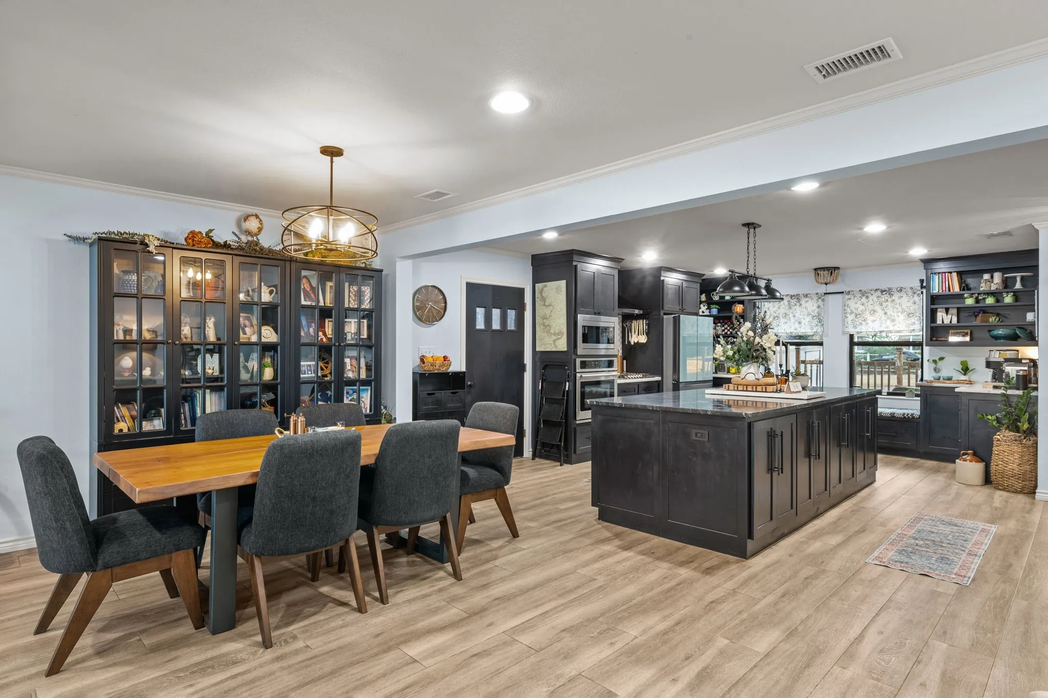 Open-concept layout featuring wood-finish flooring, recessed lighting, and crown molding