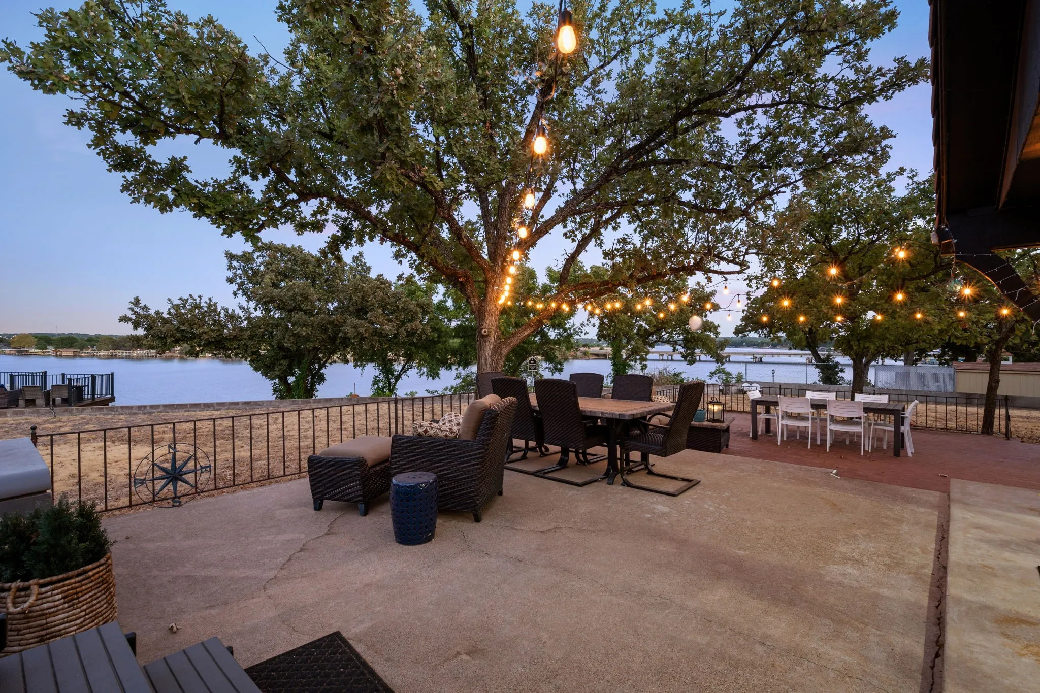Spacious outdoor patio with string lighting and water frontage