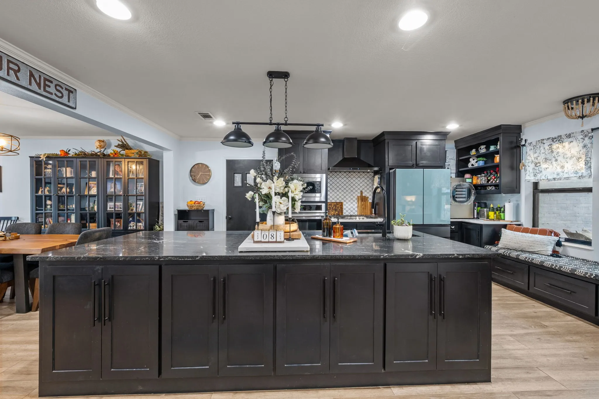 Expansive kitchen island with dark cabinetry and a polished stone-finish countertop