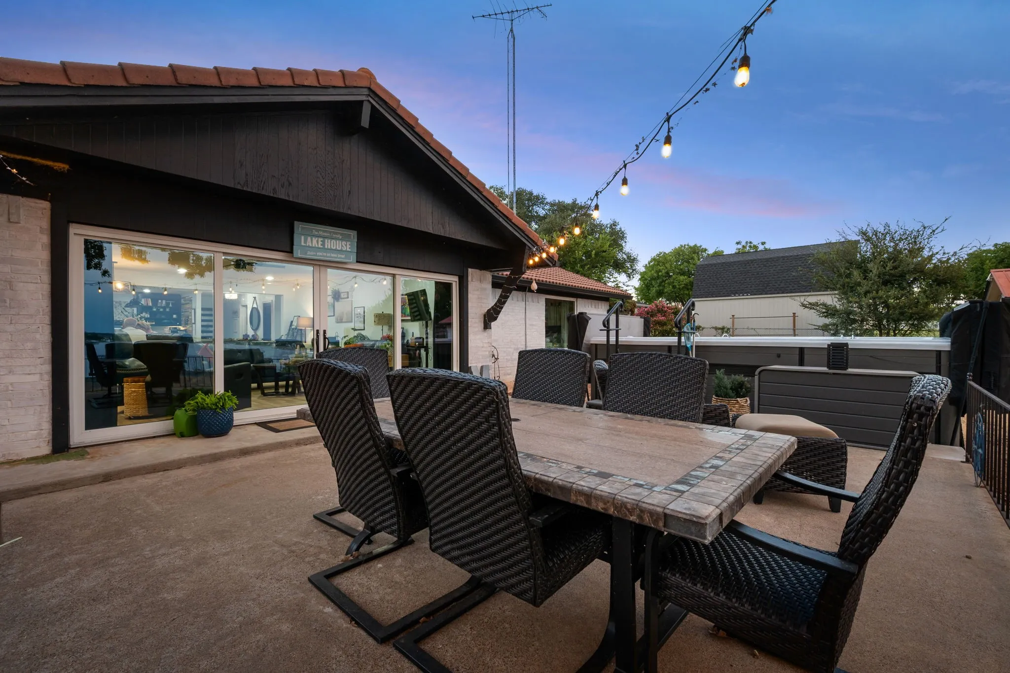 Concrete patio featuring string lights and a large built-in spa
